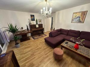 uma sala de estar com um sofá e um piano em Ave de la vaite em Besançon