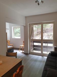 a living room with a large window and a table at Résidence les Campanules appartement entièrement rénové à 100m des pistes in Villarodin-Bourget