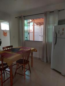 uma sala de jantar com uma mesa e um frigorífico em Casa em São Lourenço-MG em São Lourenço