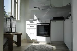 a white kitchen with a stove and a sink at Tyylikäs hyvin varusteltu asunto. Oma autopaikka. in Salo