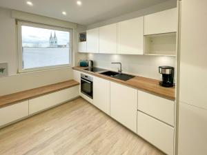 a kitchen with white cabinets and a window at Ferienwohnung Schönes Maifeld in Polch