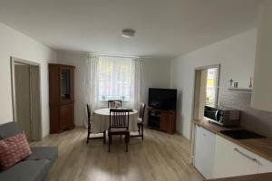 a kitchen and a living room with a table and chairs at Dům nad Jezerem - apartmán I. in Most