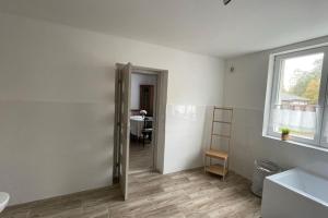 um quarto branco com uma casa de banho com um lavatório e uma janela em Dům nad Jezerem - apartmán I. em Most