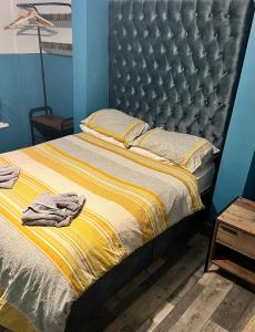 een bed met een zwart hoofdeinde en een gele deken bij Oak 2 Bed Apartment (Plus Sofa Bed - Sleeps 6) in Blackpool