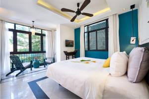 a bedroom with a large bed with a ceiling fan at Maison Vy Hotel in Hoi An