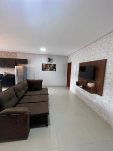 uma sala de estar com um sofá e uma televisão de ecrã plano em KSAKONCHEGO Olimpia SP em Olímpia