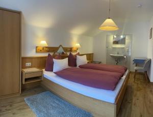 a bedroom with a large bed and a bathroom at Das Weber in Sankt Jakob in Defereggen