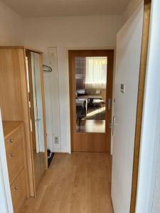 Zimmer mit einem Flur mit einer Holztür und einer Küche in der Unterkunft Apartment in einer ruhigen Umgebung in Graz in Graz