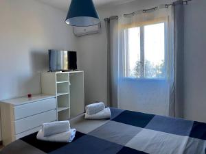 um quarto com uma cama azul e branca e uma janela em HOME D&D em Niscemi