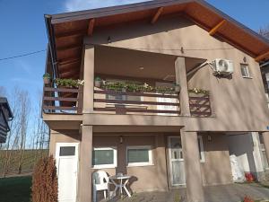 a building with a balcony with plants on it at Vikendica apartments Dunav MS in Čelarevo