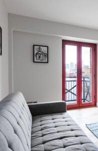 City Riverview Apartment with Parking في لندن: غرفة معيشة مع أريكة ونافذة