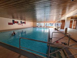 a person swimming in a large indoor swimming pool at Ferienwohnung Missen-Wilhams in Missen-Wilhams