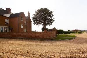 a brick house with a tree in front of it at Dunnimere Farm stay with Hot Tub - up to 20 in Haselour