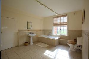 a bathroom with a tub and a toilet and a sink at Dunnimere Farm stay with Hot Tub - up to 20 in Haselour +30 photos