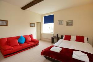a bedroom with a bed and a red couch at Dunnimere Farm stay with Hot Tub - up to 20 in Haselour