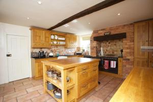 a large kitchen with wooden cabinets and a counter top at Dunnimere Farm stay with Hot Tub - up to 20 in Haselour