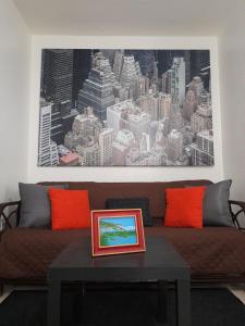聖胡安的住宿－Cozy Apartment across the San Juan Airport，客厅配有带橙色枕头的棕色沙发