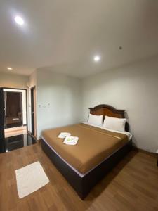 ein Schlafzimmer mit einem Bett mit zwei Handtüchern darauf in der Unterkunft Bakkahland Farm and Resort in Pattani