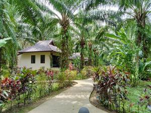 a small house in a garden with palm trees at Khao Sok Palm Garden Resort in Khao Sok National Park