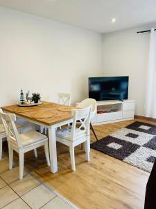 comedor con mesa, sillas y TV en Maisonette Wohnung Sophie mit Balkon und Terrasse, en Weikersheim