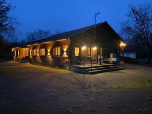 的住宿－Camping de Messeugne，一座大型的木制建筑,晚上有灯