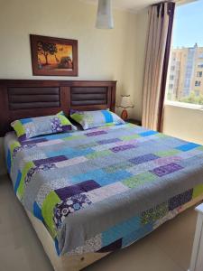 a bed with a quilt on it in a bedroom at Bahía Pelicanos Catalina in Ventanas