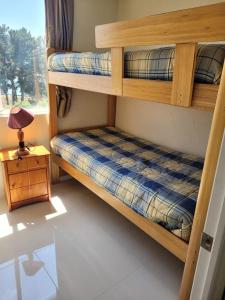 a bedroom with two bunk beds and a lamp at Bahía Pelicanos Catalina in Ventanas