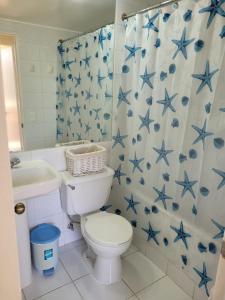 ein Badezimmer mit einem WC und einem Duschvorhang mit blauen Sternen in der Unterkunft Bahía Pelicanos Catalina in Ventanas