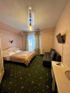 een hotelkamer met een bed en een bank bij Viktan Hotel in Boekovel