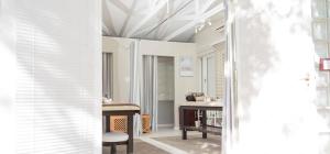 a hallway with white walls and a table and chairs at 5 Mountains Lodge & Spa in Wellington