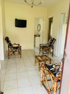 ein Wohnzimmer mit Stühlen und einem Flachbildfernseher in der Unterkunft Aguas de São Pedro ambiente Familiar e Aconchegante in São Pedro