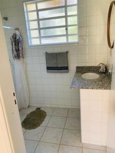 a white bathroom with a sink and a shower at Aguas de São Pedro ambiente Familiar e Aconchegante in São Pedro