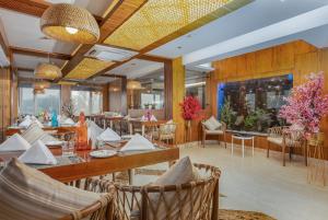 un restaurante con mesas y sillas en una habitación en Hotel Meerz, en Srinagar