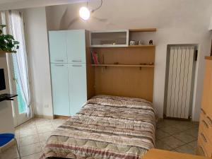a bedroom with a bed and a cabinet in it at Casa del vecchio artista in Imperia