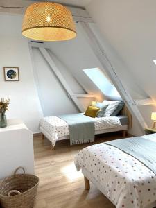 a attic room with two beds and a ceiling at Maison de vacances dans un village de charme 