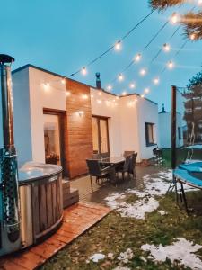 a patio with a table and chairs and lights at Holiday House Palanga with Hot Tub in Palanga