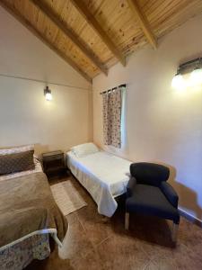 1 dormitorio con 1 cama y 1 silla en Valle Puelo en Lago Puelo
