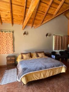 a bedroom with a bed in a room with wooden ceilings at Valle Puelo in Lago Puelo