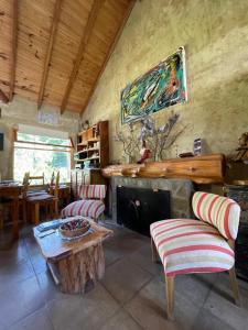 sala de estar con chimenea, mesa y sillas en Valle Puelo en Lago Puelo