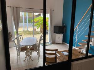 a dining room with a table and chairs and a balcony at La cabane de Lily - T2 classé 3 étoiles in Rochefort +7 photos