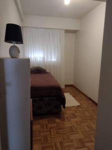 Un dormitorio con una cama y una lámpara. en Hermoso departamento en la mejor zona de Recoleta. en Buenos Aires