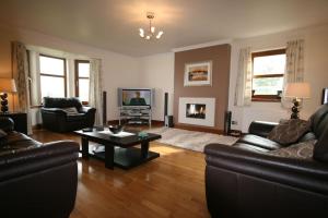 Una sala de estar con dos sofás y una mesa de café. en Ardmore luxury self catering cottage, en Broadford