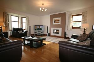 a living room with two couches and a coffee table at Ardmore luxury self catering cottage in Broadford