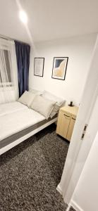 a small bedroom with a bed and a table at Apartamenty Daniłowskiego in Piotrków Trybunalski