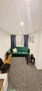 a living room with a green couch and a table at Apartamenty Daniłowskiego in Piotrków Trybunalski +70 photos