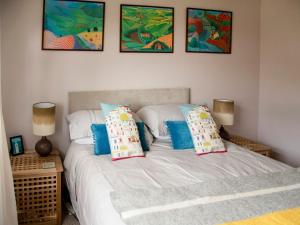 1 dormitorio con 2 camas y 2 lámparas y pinturas en Waves And Wolds, en Sewerby
