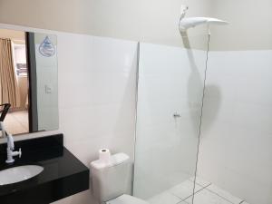 een badkamer met een toilet en een glazen douche bij Hotel Itatiaia in Tangara da Serra