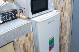 a microwave sitting on top of a refrigerator at Hotel Kingdom Appartments in Mwanza