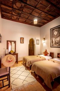 a bedroom with two beds and a wooden ceiling at Riad & Spa Bahia Salam in Marrakesh