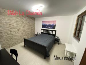 a bedroom with a bed and a brick wall at La Ciuenda in Perosa Argentina